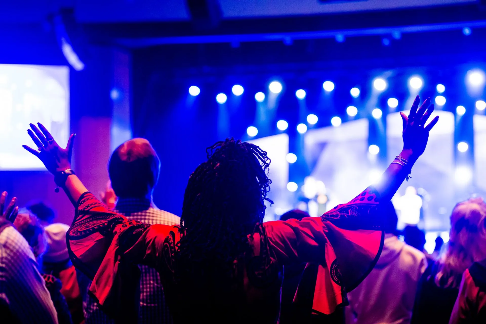 The crowd, hands raised toward the stage